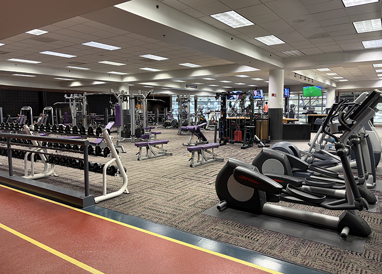 Large room filled with free weights and fitness equipment.