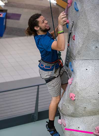 Student climbing rock wall in WRC on UNI Campus